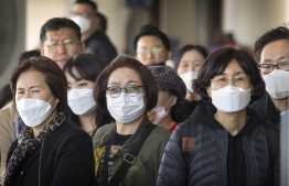 Passengers wear face masks to protect against the spread of the Coronavirus as they arrive on a flight from Asia at Los Angeles International Airport, California, on January 29, 2020. - A new virus that has killed more than one hundred people, infected thousands and has already reached the US could mutate and spread, China warned, as authorities urged people to steer clear of Wuhan, the city at the heart of the outbreak. (Photo by Mark RALSTON / AFP)