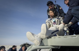 This NASA handout photo shows NASA astronaut Christina Koch as she is helped out of the Soyuz MS-13 spacecraft just minutes after she, Roscosmos cosmonaut Alexander Skvortsov, and ESA astronaut Luca Parmitano, landed in a remote area near the town of Zhezkazgan, Kazakhstan on February 6, 2020. - Koch returned to Earth after logging 328 days in space --- the longest spaceflight in history by a woman --- as a member of Expeditions 59-60-61 on the International Space Station. Skvortsov and Parmitano returned after 201 days in space where they served as Expedition 60-61 crew members onboard the station. (Photo by Bill INGALLS / NASA / AFP) / 