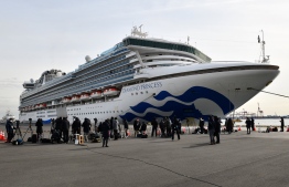 A Japanese Self-Defense Forces Health Corps vehicle enters a cordoned-off area at the Daikoku Pier Cruise Terminal where the quarantined Diamond Princess cruise ship (rear) is anchored, in Yokohama on February 7, 2020, as over 3,700 people remain quarantined onboard due to fears of the new coronavirus. At least 61 people on board a cruise ship off Japan have tested positive for the new coronavirus, the government said February 7, as thousands of passengers and crew face a two-week quarantine.