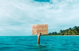 A climate activist holds a sign which reads, "are you waiting until we sink?". PHOTO: TWITTER/ VISITLAAMU