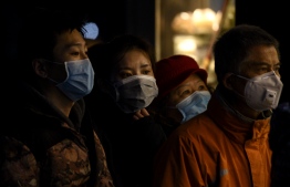 People wearing protective facemasks queue to order food from a stall in Shanghai on February 14, 2020. - Youan Hospital is one of twenty hospitals in Beijing treating coronavirus patients. Six health workers have died from the COVID-19 coronavirus in China and more than 1,700 have been infected, health officials said on February 14, underscoring the risks doctors and nurses have taken due to shortages of protective gear. (Photo by NOEL CELIS / AFP)