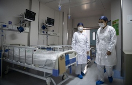 Nurses walk inside a quarantine room at the finished but still unused building A2 of the Shanghai Public Clinical Center, where COVID-19 coronavirus patients will be quarantined, in Shanghai on February 17, 2020. - The death toll from the COVID-19 coronavirus epidemic jumped to 1,770 in China after 105 more people died, the National Health Commission said February 17. (Photo by Noel CELIS / POOL / AFP)