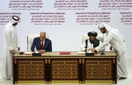 (L to R) US Special Representative for Afghanistan Reconciliation Zalmay Khalilzad and Taliban co-founder Mullah Abdul Ghani Baradar sign a peace agreement during a ceremony in the Qatari capital Doha on February 29, 2020.  (Photo by KARIM JAAFAR / AFP)