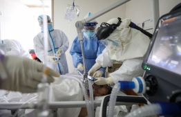 Medical staff treating a critical patient infected by the COVID-19 coronavirus with an Extracorporeal membrane oxygenation (ECMO) at the Red Cross hospital in Wuhan in China's central Hubei province on March 1, 2020. - China on March 1 reported 35 more deaths from the new coronavirus, taking the toll in the country to 2,870. (Photo by STR / AFP) / 