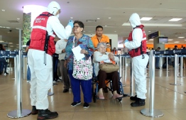 Health workers check passengers arriving at Mariscal Sucre International Airport regarding the spread of the COVID-19 virus worldwide, in Quito, on March 1, 2020. - Ecuador confirmed on the eve its first case of the COVID-19. (Photo by Cristina Vega Rhor / AFP)
