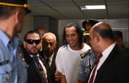 Brazilian retired football player Ronaldinho (C) arrives at Asuncion's Justice Palace to testify about his irregular entry to the country, in Asuncion, on March 6, 2020. - Former Brazilian football star Ronaldinho and his brother have been detained in Paraguay after allegedly using fake passports to enter the South American country, authorities said Wednesday. PHOTO: NORBERTO DUARTE / AFP