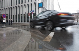 A car drives in front of the OPEC office building during the 178th meeting of the Organization of Petroleum Exporting Countries (OPEC) in Vienna, Austria, on March 6, 2020. - All eyes are on Russia at the gathering of OPEC countries and their allies, with the cartel hoping to convince Moscow to back drastic production cuts to counter the effects of the coronavirus outbreak. (Photo by ALEX HALADA / AFP)