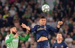 Real Madrid's Brazilian midfielder Casemiro (C) jumps for the ball with Real Betis' French midfielder Nabil Fekir (L) during the Spanish league football match between Real Betis and Real Madrid CF at the Benito Villamarin stadium in Seville on March 8, 2020. (Photo by CRISTINA QUICLER / AFP)