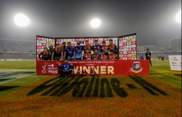 Bangladesh's cricketers pose for photographs with the trophy after winning the second Twenty20 international cricket match of a two-match series between Bangladesh and Zimbabwe at the Sher-e-Bangla National Cricket Stadium in Dhaka on March 11, 2020. PHOTO: AFP