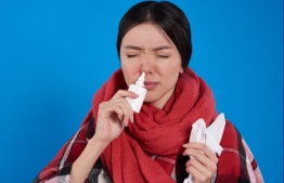 Girl suffering from cold using nasal spray.  IMAGE: STOCK PHOTOS