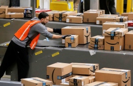 A worker prepares packages to be shipped inside of an Amazon fulfillment center in Robbinsville, New Jersey. PHOTO: REUTERS