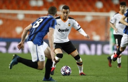 This handout photograph released by the UEFA on March 10, 2020 Valencia's Spanish forward Rodrigo Moreno (C) controlling the ball during the UEFA Champions League round of 16 second leg match between Valencia CF and Atalanta at Estadio Mestalla in Valencia. PHOTO: GETTY / UEFA / AFP