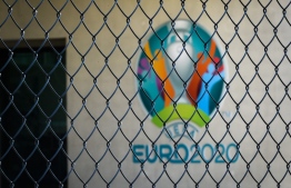 This photograph taken in Nyon on March 17, 2020, shows the Euro 2020 logo behind a fence at the headquarters of UEFA, the European football's governing body, amid spread of novel coronavirus (COVID-19). - UEFA has proposed postponing the European Championship, due to take place across the continent in June and July this year, until 2021 at crisis meetings on Tuesday, a source close to European football's governing body told AFP. (Photo by FABRICE COFFRINI / AFP)
