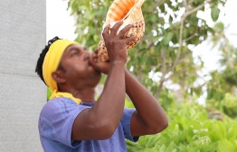 A resort worker blowing a conch shell. Decades ago, the blowing of the conch was a call for island communities to gather, signalling a matter of great importance or requiring urgent attention. These days, certain resorts marry nostalgia with tradition and use it to greet guests upon arrival.  PHOTO: HAWWA AMAANY ABDULLA/ THE EDITION
