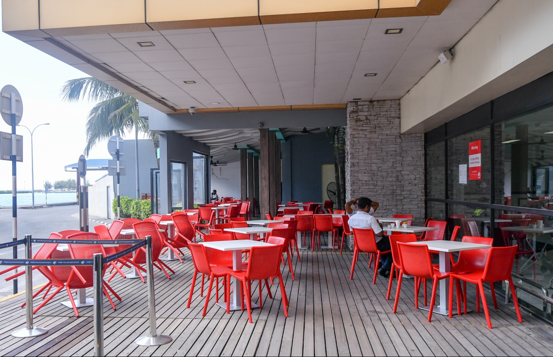 ހުޅުލެ: މާޗް 30، 2020: ކޮވިޑް-19 އާ ގުޅިގެން ހުރިހާ އެއާލައިންތަކެއް ދަތުރުތައް ހުއްޓާލުމާއި ގުޅިގެން  ޑޮމެސްޓިކް އެއާޕޯޓުގެ ކެފޭ ތެރޭގައި މީހަކު އިށީނދެލައިގެން. ފޮޓޯތައް: ނިޝާން އަލީ /މިހާރު