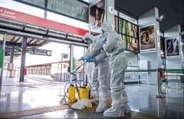 Medical workers disinfect a train station along the Spain-Portuguese border earlier this month. PHOTO: AP