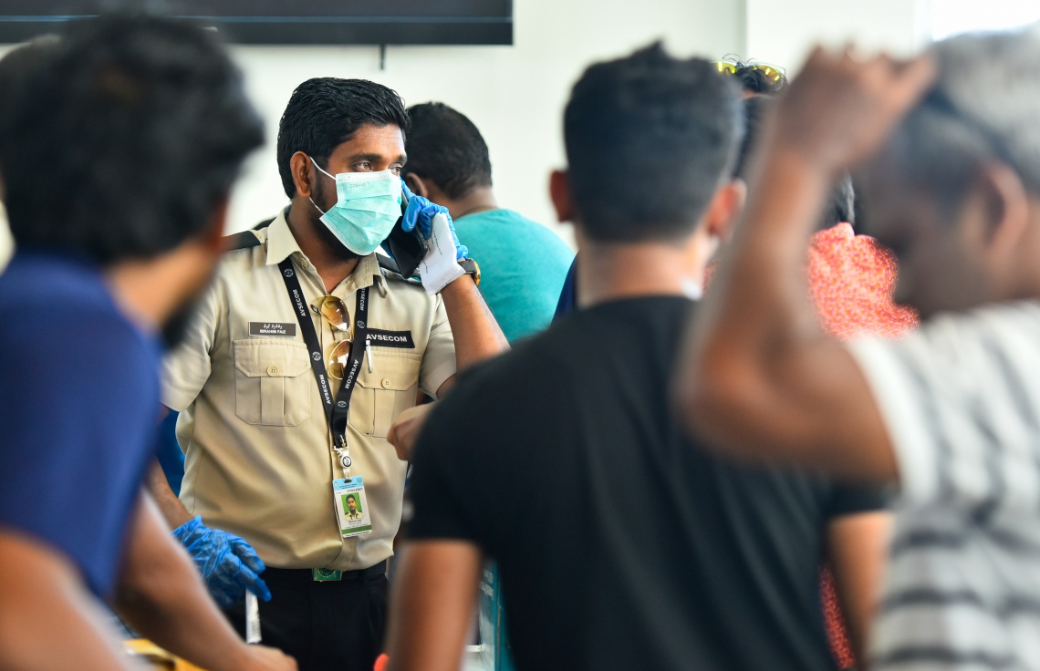 މާލެ- އޭޕްރީލް 4، 2020- ރާއްޖޭގެ ގައުމީ އެއާލައިން މޯލްޑިވިއަން އިން ސްރީ ލަންކާ އަށް ބާއްވާ ކާގޯ ދަތުރުގައި، އެ ގައުމުގައި ތިބި ދިވެހި އާއިލާތަކަށް ތަކެތި ފޮނުވުމަށް ބަސް ޓާމިނަލްގައި ހުންނަ މޯލްޑިވިއަން ކައުންޓަރު ކައިރީގައި ބަޔަކު ކިއޫ ހަދާފައިވާއިރު، އޭވިއޭޝަން ސެކިއުރިޓީ އޮފިސަރަކު މީހާ ފޯނުން ވާހަކަ ދައްކަނީ.---ފޮޓޯ: އަހުމަދު އަވްޝަން/މިހާރު