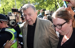 (FILES) This file photo taken on February 27, 2019 shows Australian Cardinal George Pell (C) making his way to the court in Melbourne. - Cardinal George Pell will walk free from jail after winning a long-running battle to overturn his child sex abuse convictions in Australia's High Court on April 7, 2020. (Photo by Con CHRONIS / AFP)