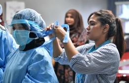 A nurse at Indira Gandhi Memorial Hospital demonstrates how to don Personal Protective Equipment (PPE) for doctors and nurses working at the critical care units. PHOTO: ALI NISHAN/ MIHAARU