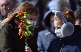 Catholic Christian believers wearing nose and mouth face masks, amid concerns over the spread of the COVID-19, the novel coronavirus, attend the Sunday service on April 5, 2020, in the town of Achmiany, some 130 km northwest of Minsk, during Palm Sunday celebrations which mark a week before Easter. (Photo by Sergei GAPON / AFP)