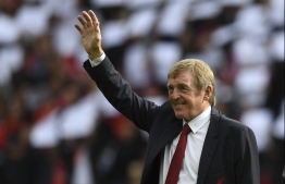 (FILES) In this file photo Former Liverpool player and manager Kenny Dalglish takes the applause of the supporters a day after having the new grandstand named after him, on the pitch ahead of the English Premier League football match between Liverpool and Manchester United at Anfield in Liverpool, north west England on October 14, 2017. - Liverpool legend Kenny Dalglish has tested positive for coronavirus but is not showing symptoms of the disease, his family said Friday. (Photo by Paul ELLIS / AFP) / RESTRICTED TO EDITORIAL USE. No use with unauthorized audio, video, data, fixture lists, club/league logos or 'live' services. Online in-match use limited to 75 images, no video emulation. No use in betting, games or single club/league/player publications. / 