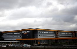 (FILES) A file photo taken on November 28, 2019 shows the Amazon logo at one of the company's centre in Bretigny-sur-Orge. - Masks for all French employees, temperature control throughout the network: the American giant of online retail group Amazon reacted on April 3, 2020 to the grumbling of its employees, without really calming concerns over the coronavirus epidemic. (Photo by Thomas SAMSON / AFP)