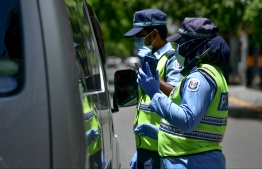 Maldives Police Service verifying a vehicle for permits during the travel restrictions and curfew intiially imposed in the Greater Male' Region amid the ongoing COVID-19 outbreak in the country. PHOTO: NISHAN ALI / MIHAARU