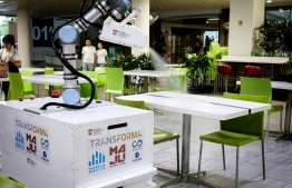 This undated handout from the Nanyang Technological University (NTU) Singapore released on April 15, 2020 shows the eXtreme Disinfection roBOT (XDBOT), a semi-autonomous robot, as it disinfects a table in an eating area of the NTUsg Smart Campus in Singapore. - Singapore researchers have invented a disinfecting robot with an arm that mimics human movement, to help take the load off overworked cleaners during the coronavirus pandemic. (Photo by Handout / NTU SINGAPORE / AFP) / -----EDITORS NOTE --- RESTRICTED TO EDITORIAL USE - MANDATORY CREDIT "AFP PHOTO / NTU SINGAPORE" - NO MARKETING - NO ADVERTISING CAMPAIGNS - DISTRIBUTED AS A SERVICE TO CLIENTS  - NO ARCHIVE