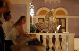 Members of Qatar's Philharmonic Orchestra perform from their balconies to punctuate the monotony of social distancing as the weekend begins, April 17, 2020 in Doha during the coronavirus COVID-19 pandemic. (Photo by - / AFP)