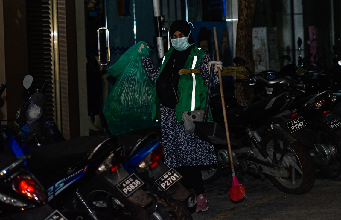 މާލެ: އޭޕްރިލް 18، 2020: މާލެ ސަރަހައްދު ލޮކްޑައުން ކޮށްފައި ވިޔަސް، ޚާއްސަ ފިޔަވަޅުތަކާ އެކު ކުނި އުކުމުގެ ޚިދުމަތް ވެމްކޯ އިން ކުރިއަށް ގެންދިއުމަށް ހަމަޖެހިފާވާއިރު، ވެމްކޯގެ މުވައްޒަފަކު މާލޭގެ މަގުމަތި ކެހުމަށް ތައްޔާރުވެފައި.-- ފޮޓޯ: އަހުމަދު އަވްޝަން /މިހާރު