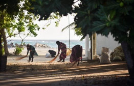 Women pictured sweeping the beach in local island Uligan in Haa Alfu Atoll. Seven islands in Haa Alifu and Haa Dhaalu Atoll are now under lockdown in connection with the first recorded COVID-19 case in the capital. PHOTO: ARUSHAD AHMED/FLICKR