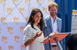 (FILES) In this file photo taken on October 2, 2019 Meghan, Duchess of Sussex (L), is watched by Britain's Prince Harry, Duke of Sussex (R) as she delivers a speech at the Youth Employment Services Hub in Tembisa township, Johannesburg. - Britain's Prince Harry and his wife Meghan handed out meals to sick people in Los Angeles, in their first known public activity since moving to California at the start of the state's coronavirus lockdown. The pair, who have formally stepped down as senior members of the British royal family, first volunteered with Project Angel Food last on April 12, 2020, delivering food to homes. (Photo by Michele Spatari / AFP)