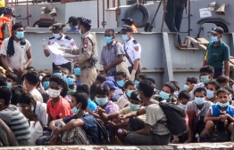 This screengrab from video taken on April 20, 2020 shows released Rohingya prisoners, wearing face masks amid concerns of the COVID-19 coronavirus pandemic, arriving in Sittwe jetty in Rakhine State after being transported by a military boat. - Myanmar sent more than 800 Rohingya back to its restive Rakhine state April 20 after releasing them from various overcrowded jails as the country, accused of genocide against the minority, tries to grapple with the coronavirus crisis. (Photo by STR / AFP)
