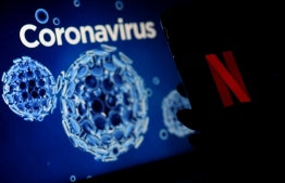 (FILES) In this file photo illustration taken on March 31, 2020, a mobile phone screens display the Netflix logo next to a coronavirus, COVID-19, illustration graphic background in Arlington, Virginia. - Netflix on April 21, 2020, reported its quarterly profit more than doubled as subscriptions surged at the streaming television service during the pandemic. Netflix made a profit of $709 million on revenue of $5.8 billion in the first three months of this year, while the number of subscribers grew by 15.7 million to total nearly 183 million, according to earnings figures. (Photo by Olivier DOULIERY / AFP)