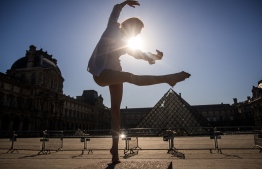 Syrian dancer and choreographer Yara al-Hasbani performs a dance in front of the Louvre museum's pyramid in Paris on April 22, 2020, on the 37th day of a strict lockdown in France to stop the spread of COVID-19 (novel coronavirus). (Photo by Sameer Al-DOUMY / AFP)