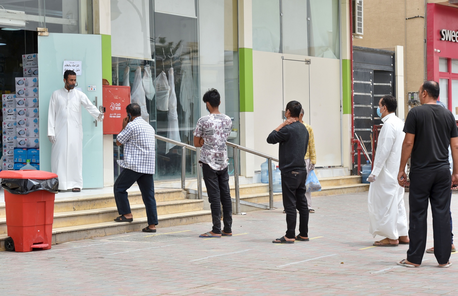 ކޮރޯނާވައިރަހާ ގުޅިގެން ލޮކްޑައުންކޮށްފައިވާ ސައުދީ އަރަބިއާގެ ވެރިރަށް ރިޔާޒުގެ ފިހާރައެއްގެ ބޭރުގައި، ދުރުމިން ބަހައްޓައިގެން ކިޔޫ ހަދާފައި. މިއީ ދެން ކަންވާނެ ގޮތް --ފޮޓޯ:އޭއެފްޕީ