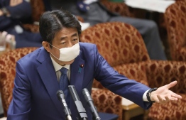 Japan's Prime Minister Shinzo Abe wearing a face mask answers questions during a upper house budget committee session at the parliament in Tokyo on April 30, 2020. (Photo by STR / JIJI PRESS / AFP) / 