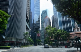 A car drives along an otherwise empty road in the financial district of Singapore on April 24, 2020, as the country undergoes a partial lockdown to fight the spread of the COVID-19 novel coronavirus. (Photo by Roslan RAHMAN / AFP)