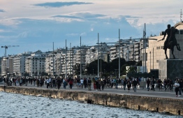 People walk on the waterfront of Thessaloniki on May 1, 2020, after one month of banned access for promenade as measure adopted to prevent the spread of the COVID-19 (the novel coronavirus). - Greek Prime Minister announced on April 28, 2020 a gradual easing of coronavirus lockdown rules from May 4 but said implementation would be monitored daily. (Photo by Sakis MITROLIDIS / AFP)