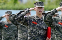 This handout photo taken on May 8, 2020 and published on the official Facebook page of the Republic of Korea Marine Corps shows Tottenham Hotspur's South Korean striker Son Heung-min in military uniform saluting during a basic military training completion ceremony at a marines boot camp in Jeju island. - Tottenham Hotspur striker Son Heung-min was named one of the top five recruits in his unit as he finished three weeks of compulsory military training in South Korea on May 8. PHOTO: REPUBLIC OF KOREA MARINE CORPS / AFP