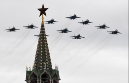Russian Sukhoi Su-35S fighter aircrafts, Su-34 military fighter jets and Su-30SM jet fighters fly over the Kremlin and Red Square in downtown Moscow to mark the 75th anniversary of the victory over Nazi Germany in World War Two, May 9, 2020. PHOTO: YURI KADOBNOV / AFP