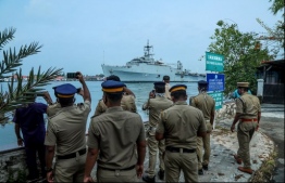 Kerala police personnel watch and take photos as the INS Jalashwa ship enters the Cochin port carrying Indian citizens who were stranded in Maldives due to the COVID-19 coronavirus disease, in Kochi in the south Indian state of Kerala on May 10, 2020. PHOTO: AFP