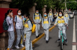 Students wearing face masks amid concerns of the COVID-19 coronavirus leave a middle school in Beijing on May 11, 2020. - Students in a number of cities including Shanghai and Beijing began returning to classes in late April, starting with high schoolers. (Photo by NICOLAS ASFOURI / AFP)