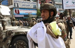 An Afghan soldier cradles a baby in his arms after the attack in Kabul in May 2020. PHOTO: MIHAARU FILES