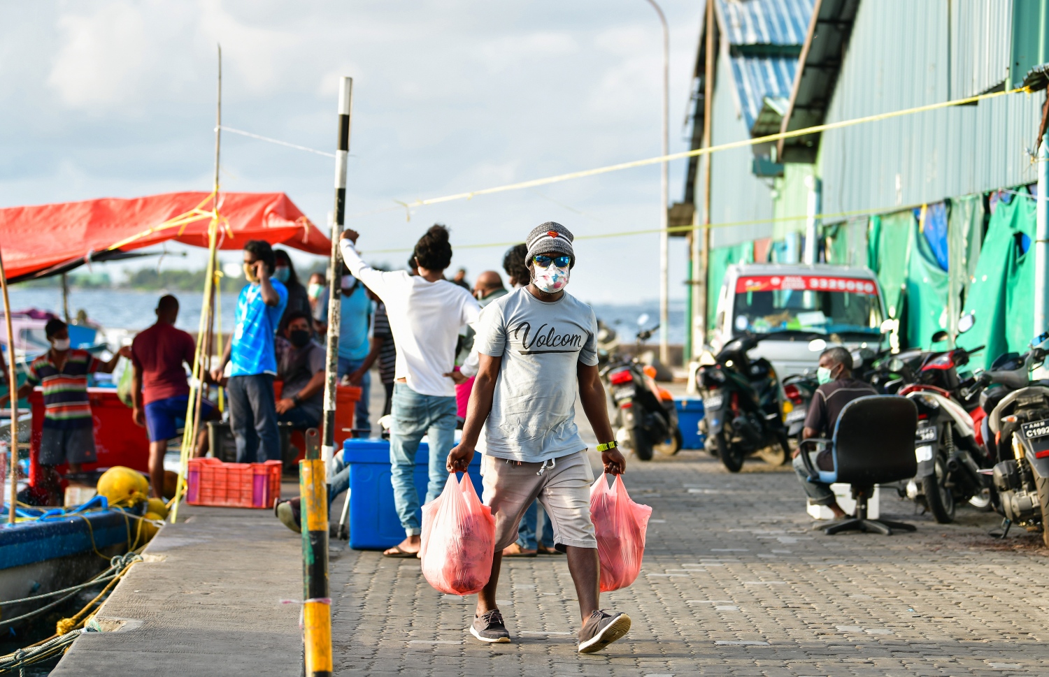 ބާޒާރުމަތިން މީހަކު މަސް ގަނެގެން ހިފައިގެން ދަނީ.-- ފޮޓޯ: އަހުމަދު އަވްޝަން / މިހާރު