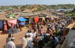 Rohingya refugees gather at a market as first cases of COVID-19 coronavirus have emerged in the area, in Kutupalong refugee camp in Ukhia on May 15, 2020. - Emergency teams raced on May 15 to prevent a coronavirus "nightmare" in the world's largest refugee settlement after the first confirmed cases in a sprawling city of shacks housing nearly a million Rohingya. (Photo by Suzauddin RUBEL / AFP)