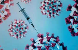 A syringe is pictured on an illustration representation of COVID-19, the disease caused by the novel coronavirus in Paris on May 18, 2020. (Photo by JOEL SAGET / AFP)