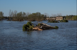 A roof floats in the water in the town of Sanford, Michigan after flood waters from heavy rains carried over from the weekend caused mass flooding throughout central Michigan, on May 20, 2020. - More than 10,000 residents were evacuating their homes in Michigan on May 20, 2020 after two dams failed following heavy rain and triggered what officials warned will be historic flooding. Governor Gretchen Whitmer declared a state of emergency in Midland County, site of the breached dams, in the towns of Edenville and Sanford. (Photo by SETH HERALD / AFP)
