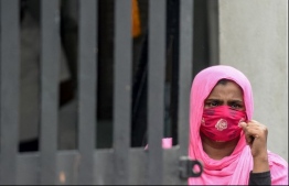 A relative of three women trampled to death as they were waiting to receive an eight-dollar cash donation at a businessman's warehouse, stands outside a morgue in Colombo on May 22, 2020. PHOTO: AFP