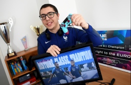 Lotfi Derradji, 21 years old, one of the two players of the French eFoot team, poses with his computer screen, on May 20, 2020 in Villepinte near Paris. - The Euro football tournament will take place in 2020 ... but as a video game. Despite the postponement of the European Championship to 2021, UEFA has maintained its "esport" version which will be played online this weekend, to "reach a new audience, consuming the sport in a completely different way". PHOTO: FRANCK FIFE / AFP